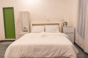 a bedroom with a large white bed with a green door at Faafu View Maldives in Maldive Islands