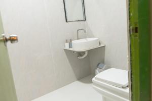 a white bathroom with a sink and a toilet at Faafu View Maldives in Maldive Islands +2 photos