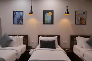 two beds in a room with pictures on the wall at Xefan Hotels in Karachi +102 photos