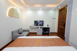a bedroom with a bed and a couch and a tv at Cortis Homestay in Nà Rẻ