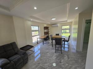 a living room with a couch and a table and chairs at Beachfront House in Garapan