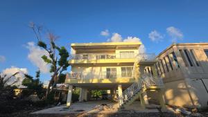 a yellow building with a staircase in front of it at Beachfront House in Garapan