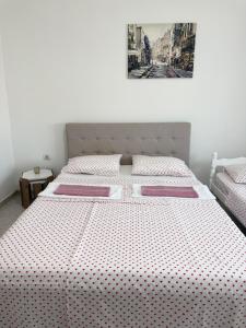 a bedroom with a large bed with polka dot sheets at Apartments Ana - Airport shuttle option in Podgorica
