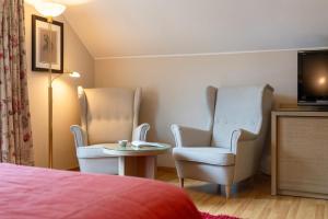 a room with two chairs and a table and a tv at Moulin de Daverdisse in Daverdisse