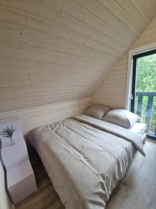 a large bed in a room with a window at Stodoła na Kaszubach in Gowidlino