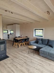 a living room with a blue couch and a table at Stodoła na Kaszubach in Gowidlino