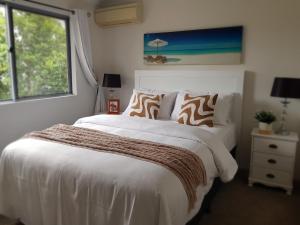 a bedroom with a large white bed and a window at "Casa Serena" - Spacious Entire Holiday Home in Caboolture +10 photos