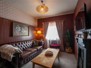 a living room with a leather couch and a table at The Mayflower in Lymington