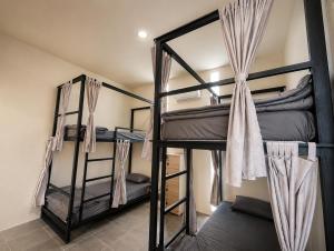 a bedroom with three bunk beds in a room at Wavez Lombok Hostel in Selong Belanak