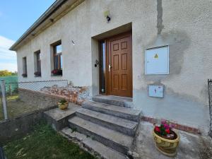a house with a wooden door and some stairs at Apartment Nová Ves 26 in Olešník