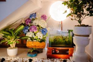 a room with flowers in vases and a fish tank at Cortis Homestay in Nà Rẻ