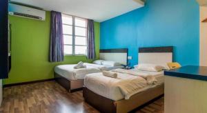 two beds in a room with green and blue walls at e Hotel in Malacca +143 photos