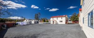 a parking lot with a white building and a mountain at Ossies Motels and Chalets in Ohakune
