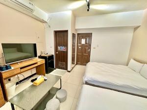 a hotel room with a bed and a television at 卡布里 in Taichung +57 photos