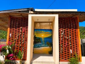 a building with a painting on the side of it at Wavez Lombok Hostel in Selong Belanak
