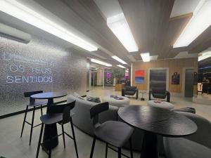 a waiting area with tables and chairs in a lobby at Life Center in Caruaru