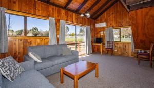 a living room with a couch and a table at Ossies Motels and Chalets in Ohakune