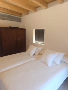 a large bed with white sheets and pillows at Benaki 92B in Ladines