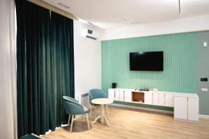 a room with two chairs and a television on a wall at National Gold Plaza in Samarkand
