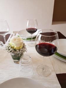 un tavolo con tre bicchieri di vino rosso sopra di Appartamento al Battistero a Oggiono