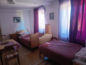 a small bedroom with two beds and a table and chairs at Zimmer A Veljanovski in Blaufelden