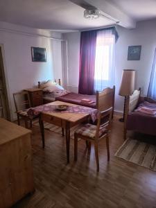 a room with a table and a bed and a table and chairs at Zimmer A Veljanovski in Blaufelden +2 photos