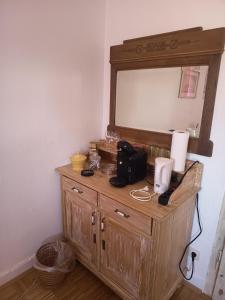 a wooden dresser with a mirror on top of it at Zimmer A Veljanovski in Blaufelden