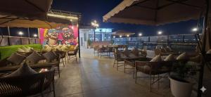a restaurant with tables and chairs and a mural at THE CROWN HOTEL & restaurants in Farrukhnagar