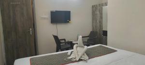 a room with a bed with a tv on the wall at M A P Hotel in Nager Bazaar