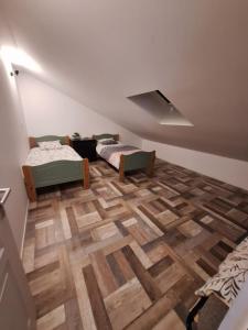 a attic room with two beds and a wooden floor at Appartement Les 3 L in Vions