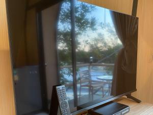 a television with a view of a patio through a window at rimbaymangroveresort in Ban Khlong Tamru