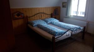 Schlafzimmer mit einem Bett mit blauer Bettwäsche und einem Fenster in der Unterkunft Pension Rybářská Bašta in Rožmberk nad Vltavou