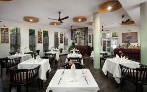 a restaurant with tables and chairs with white tablecloths at Indochine Serenity Boutique in Siem Reap