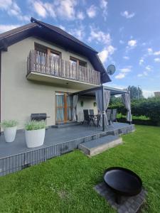 a house with a deck and a balcony at Domek nad Sołą in Cisiec