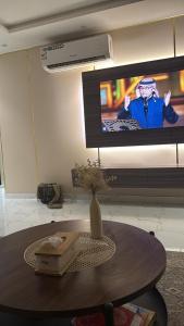 a table in a room with a television and a vase at شقة غرفتين وصالة مريحة in Jeddah