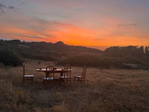 a table and chairs in a field with a sunset at Sunset and Swallows in Eaton Bishop +17 photos