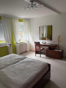 a bedroom with a bed and a desk and a mirror at Ferienwohnung Fuchs in Roding
