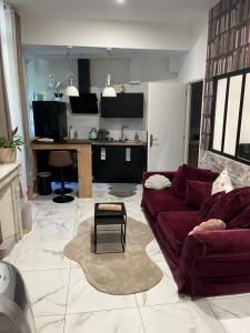 a living room with a red couch and a kitchen at Souad in Saint-Vallier