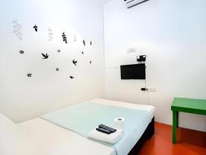 a room with a bed with butterflies on the wall at Dormitelsph BGC in Manila
