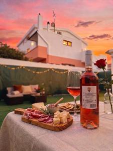 a bottle of wine and a plate of food and a glass at In DhomeU Tua - Free Wifi & Private Garden in Selargius