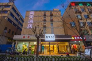 a building with a sign in front of it at 7 Days Inn Baoding Railway Station in Baoding