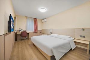 a bedroom with a large white bed and a desk at 7 Days Inn Baoding Railway Station in Baoding