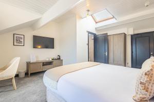 a bedroom with a bed and a desk and a tv at Falcon's Nest Hotel in Port Erin