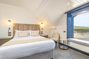 a bedroom with a large bed and a large window at Falcon's Nest Hotel in Port Erin