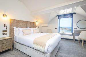 a bedroom with a large bed and a large window at Falcon's Nest Hotel in Port Erin