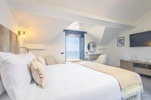 a bedroom with a large white bed and a window at Falcon's Nest Hotel in Port Erin +63 photos