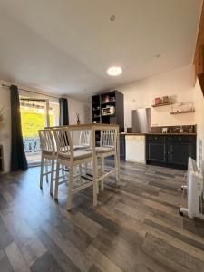 a kitchen with a table and chairs in a room at Petite maison dans le beaujolais in Les Olmes