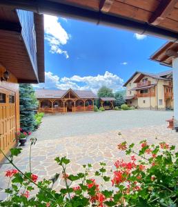 a view of a house with a courtyard with flowers at Pensiunea CARMEN Borșa in Borşa