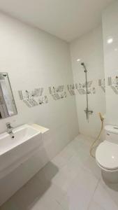 a white bathroom with a sink and a toilet at Aqua Hotel & Spa Managed by PD in Nha Trang
