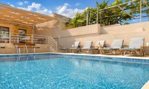 a swimming pool with chaise lounge chairs and a swimming pool at Cretan Breeze Villa Heated Pool in Dhrámia